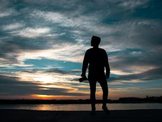 silhouette of man standing holding camera